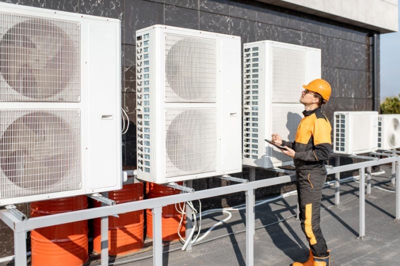 Image of technician servicing commercial hvac units. Commercial HVAC Spring Cleaning.