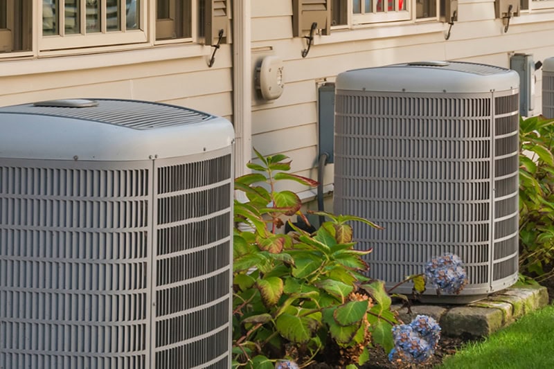 When Do I Replace My Air Conditioner in Lake Charles? Photo of two HVAC units installed outside of a home.