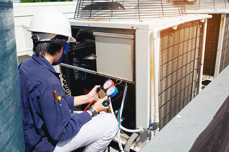 Why Is a Commercial AC Tune-Up Important? A technician fixing an HVAC unit.